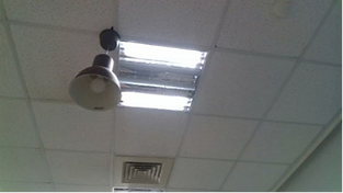 LIPSedge™ AE430 Industrial 3D Camera with Edge Processing Capability 3 Office ceiling structure featuring a hanging light, damaged recessed lighting fixture, and a ventilation grille, with some areas showing signs of damage or missing panels.