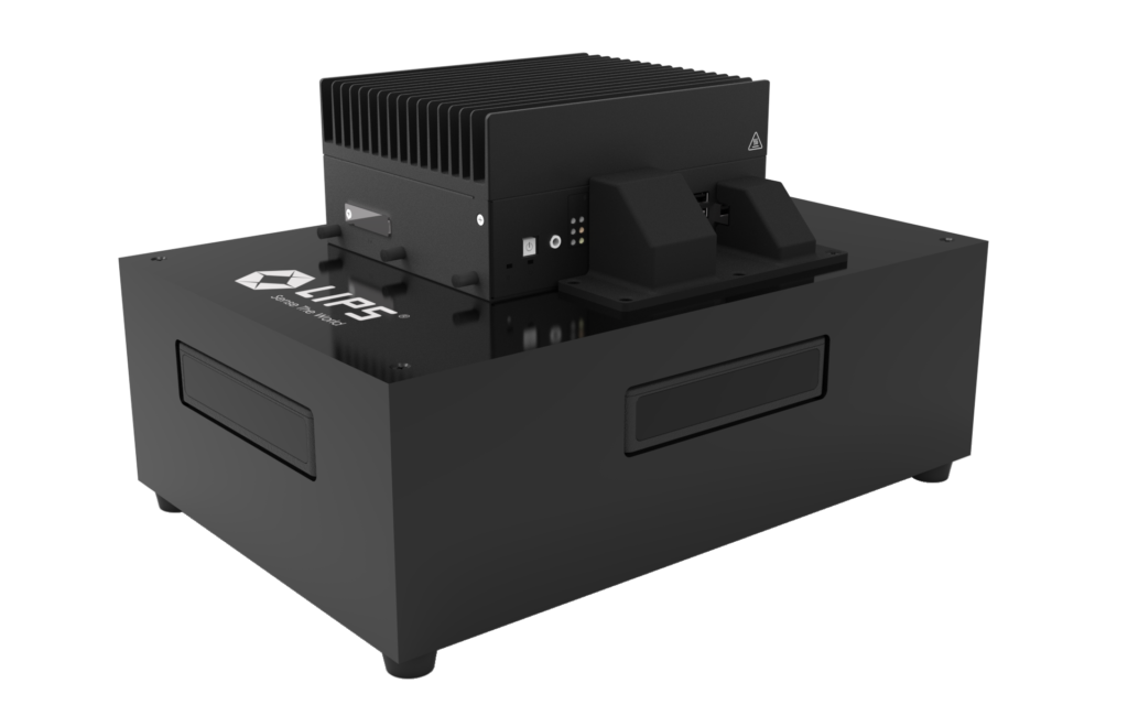 "A single black LIPS device with a compact rectangular design, cooling fins on top, and a sleek finish, displayed on a black background."