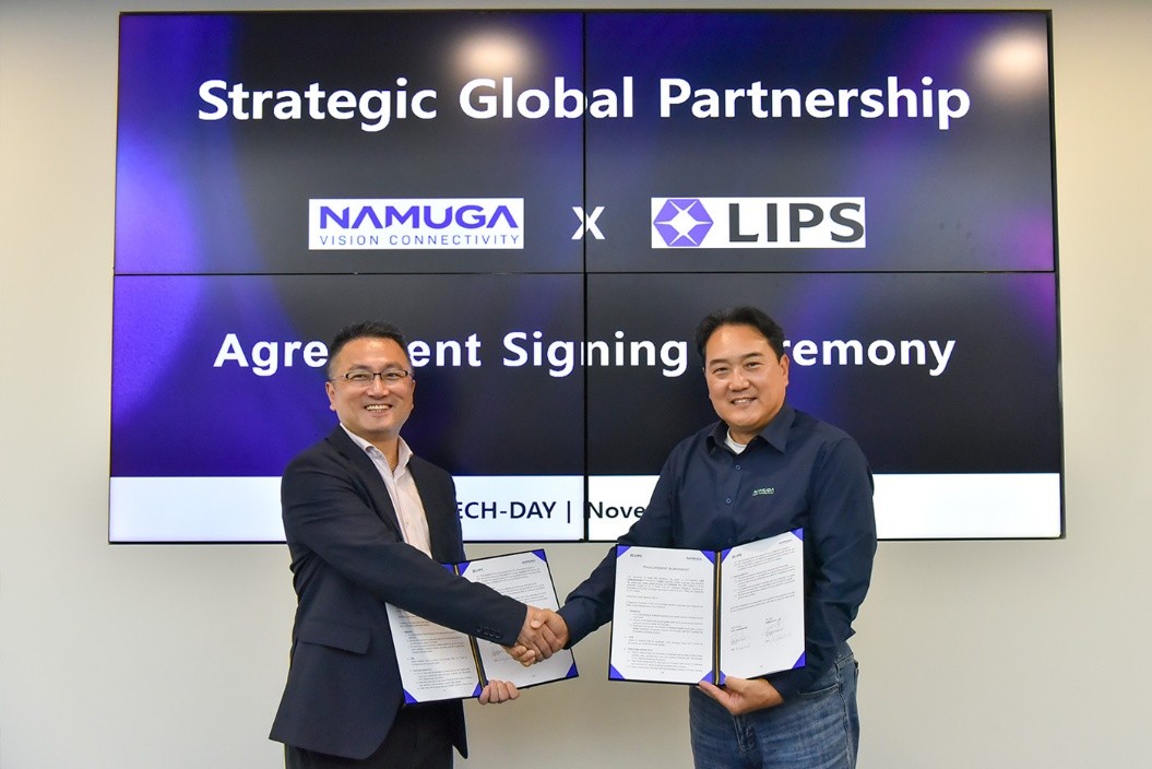 Representatives from NAMUGA and LIPS Corporation shaking hands while holding signed documents during a Strategic Global Partnership Agreement Signing Ceremony.
