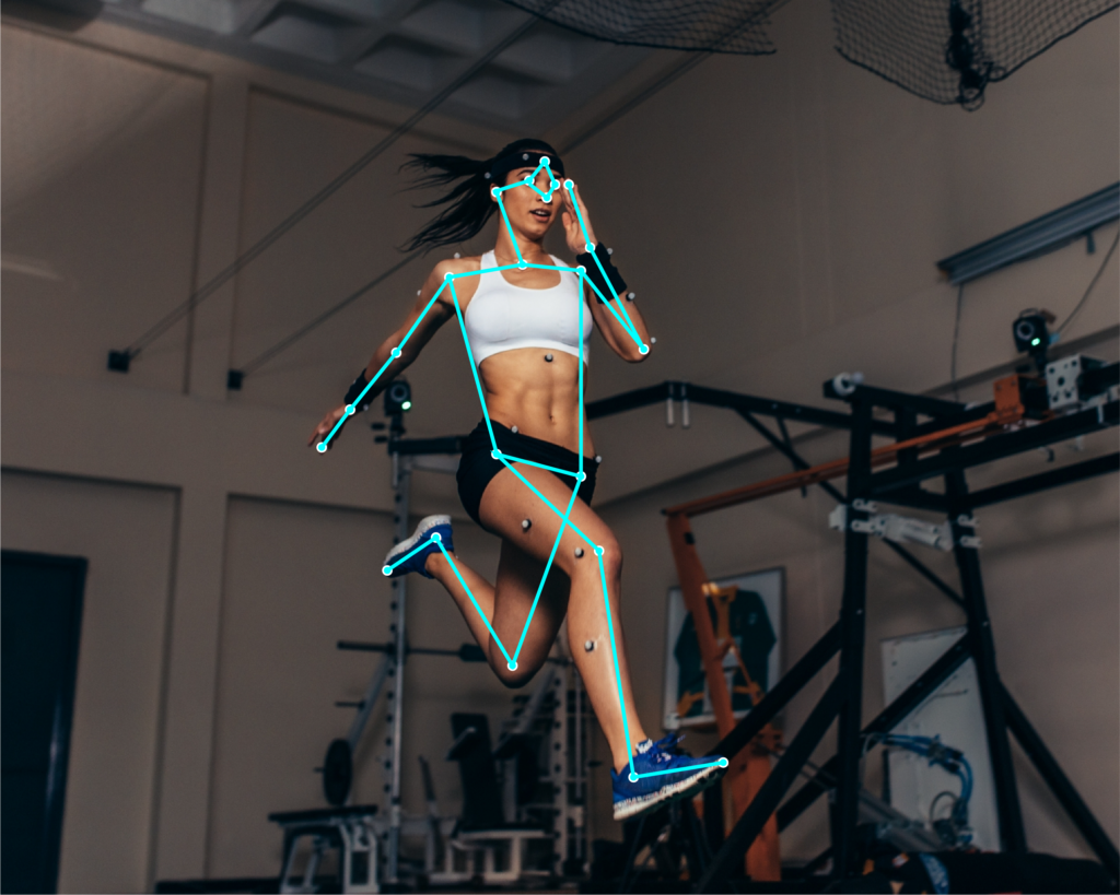 Action shot of a female athlete running in a gym with a cyan digital skeletal overlay, illustrating real-time motion capture and biomechanical performance tracking.